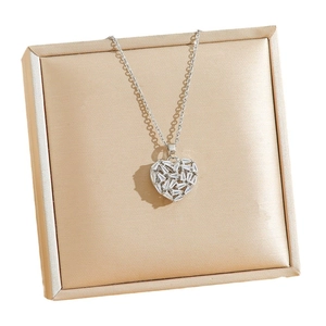 Elegant silver heart pendant necklace with zircon stones on a champagne satin jewelry box