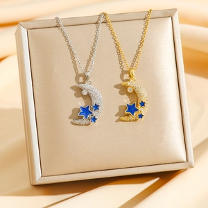 Elegant gold and silver crescent moon necklaces with blue star zircon on silk background