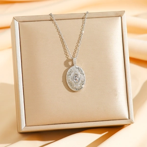 Collier avec pendentif ovale en zircon et gravure soleil sur boîte à bijoux