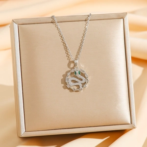 Collier serpent en argent avec zircons et œil en gemme verte sur fond de satin