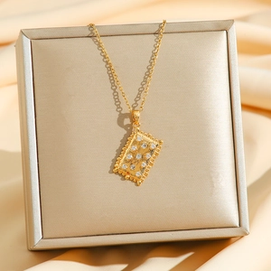 Collier doré avec pendentif rectangulaire en biscuit et zircons sur une boîte à bijoux
