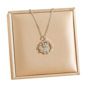 Collier pendentif ours élégant avec zircons étincelants sur un écrin à bijoux brossé