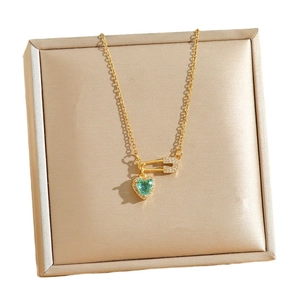 Golden pin and green heart crystal necklace on luxury silk display box