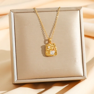 Luxury gold necklace featuring a rectangular textured lava pendant with heart and round crystals