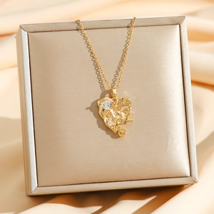 Luxurious gold heart pendant necklace with LOVE engraving and zircons on silk background