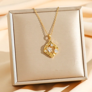 Detail of gold geometric pendant with hammered texture and zircon crystals on silk