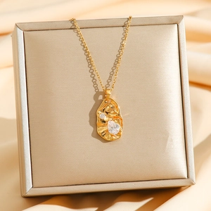 Golden irregular geometric pendant necklace with leaf texture and sparkling crystals