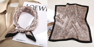 Detailed view of champagne silk square scarf with paisley pattern and black border