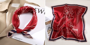 Close-up of red silk scarf with white deer pattern and navy blue striped border detail