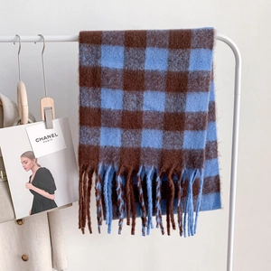 Detail of blue and coffee checkerboard mohair scarf with thick tassel edges on a hanger
