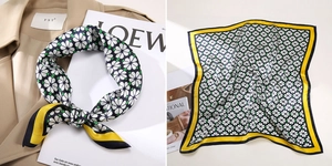 Detail of silk square scarf with white floral print on black background and yellow border