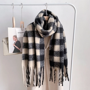 Detail of checkered mohair scarf with fringes hanging on coat showing pattern texture