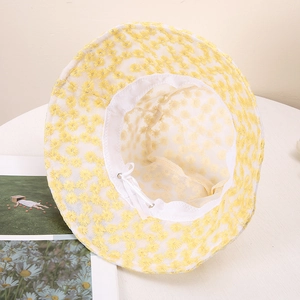 Détail de la broderie de marguerites jaunes sur un chapeau pare-soleil en maille respirante