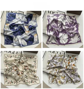 Detail showing four premium silk scarves with elegant floral patterns and hand-rolled edges