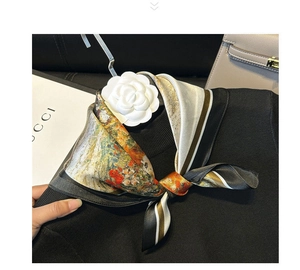 Detail of oil painting silk scarf with camellia brooch on black knitwear