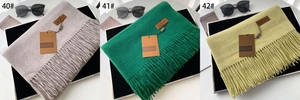 Close-up of thick winter cashmere scarves with fringe details in grey and green tones