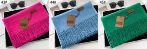 Detailed view of soft fringe scarves in magenta, light blue, and green colors