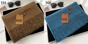 Detailed view of thick winter scarves with tassels in caramel brown and peacock blue tones