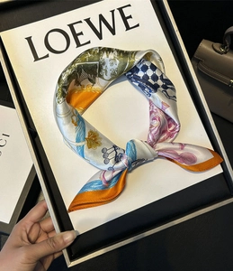 Detailed view of artistic 100% mulberry silk scarf with colorful prints and orange borders