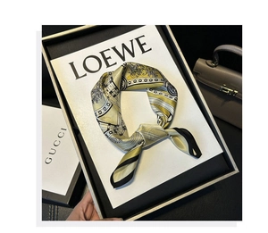 Detail eines eleganten Seidenschals in Gelb und Weiß mit Retro-Mustern und schwarzem Rand