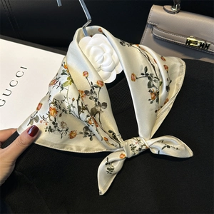 Elegant 100% silk square scarf with orange floral pattern styled on a black knit top