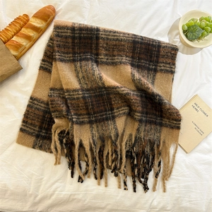 Vue détaillée d'une écharpe en mohair à carreaux épais avec franges sur fond de tissu blanc