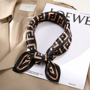 Elegant silk square scarf with geometric patterns on a trench coat background