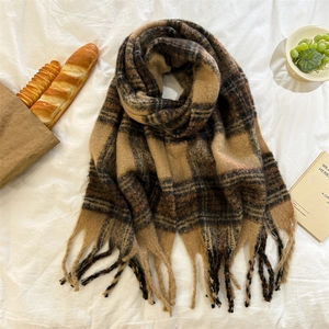 Détail d'une écharpe en mohair doux avec motifs à carreaux terreux et longues franges