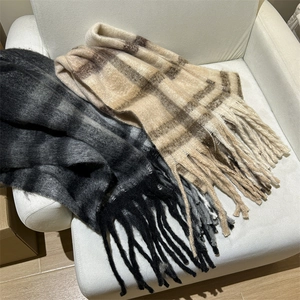 Détail d'écharpes à rayures douces avec de longues franges en gris et beige dégradé