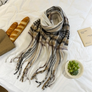 Détail d'une écharpe rayée en mohair doux avec de longues franges sur fond blanc