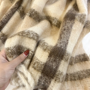 Détail macro d'une écharpe en mohair rayé doux montrant une texture épaisse et pelucheuse