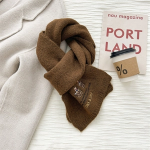 Nahaufnahme brauner Wollschal mit Bärenstickerei und Vintage-Patch für den Winter