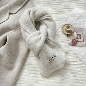 Solid cream wool knitted scarf with a minimalist label and fuzzy texture for winter