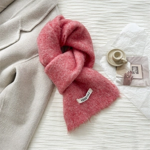 Detail of soft pink wool knit scarf with vegetable label and thick fuzzy texture