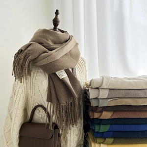 Detail of soft cashmere-feel scarf with elegant fringes and various winter colors