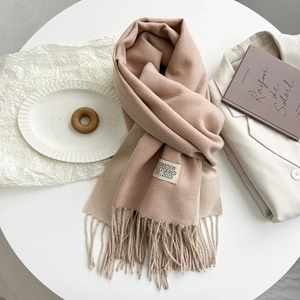 Detail view of bicolor beige and pink cashmere scarf with tassels and stitched label