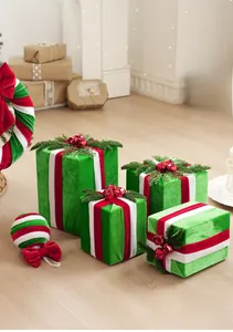 Détail de boîtes de Noël en velours vert avec rubans rayés rouges et aiguilles de pin