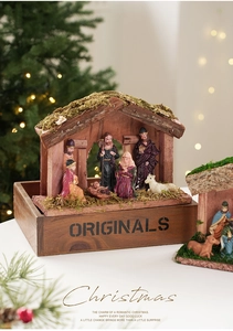 Detalle del pesebre de madera con figuras de la Sagrada Familia y techo de musgo real
