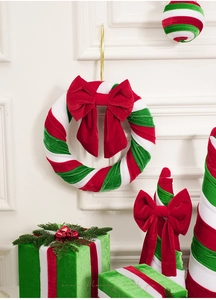 Détail de décorations de Noël en velours rouge et vert avec nœuds sur fond blanc