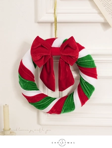 Détail d'une couronne de Noël en velours rouge et vert avec cordon doré et nœud