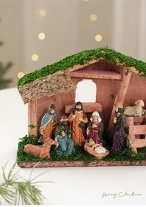 Primer plano del pesebre navideño de madera con figuras de resina y establo con musgo