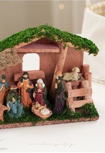 Detalle del pesebre de madera con figuras de resina y textura de musgo verde