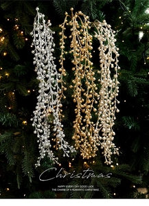 Glittering Christmas berry branches in gold and silver hanging on a festive tree background