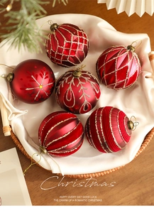 Close-up of 8cm red Christmas balls with glitter snowflake patterns in a woven tray