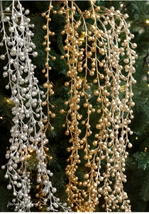 Close-up of sparkling gold and silver glitter berry stems on a festive Christmas tree