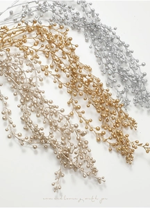 Detailed close-up of decorative Christmas glitter berry stems in gold, silver, and champagne