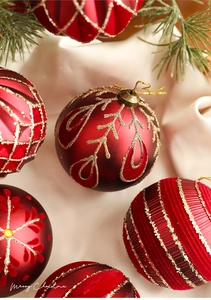 Detail of red Christmas baubles with glitter and velvet patterns on a warm winter background
