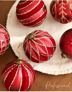 Detailed close-up of 8cm red velvet Christmas ornaments with gold glitter accents