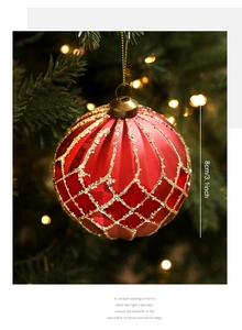 Detail of 8cm red Christmas ball with golden glitter mesh texture on a warm tree