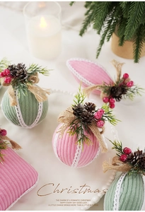 Detail of pink and green fabric Christmas ornaments with pine cones and white lace trim